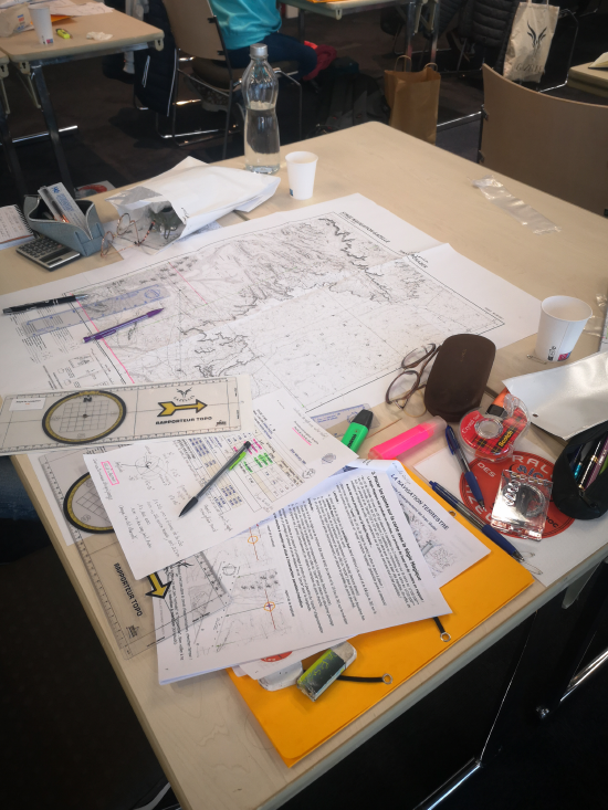 Une carte et une boussole utilisées lors d'un rallye automobile, symboles de l'expérience terrain.