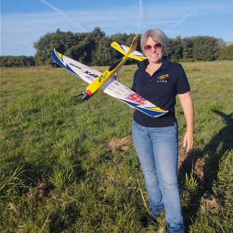 Coach professionnelle tenant un avion modèle réduit EFX preuve de sa rigueur de pilote et de sa résilience